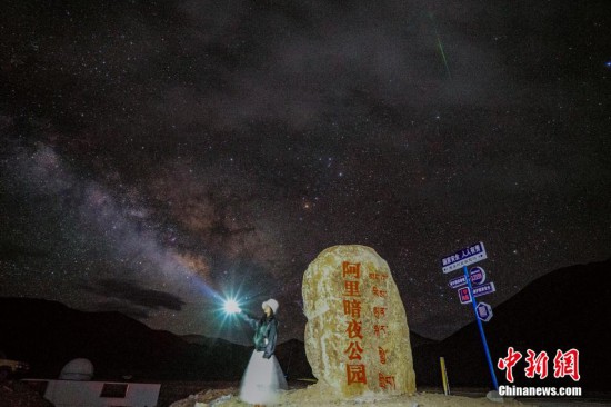 圖為6月20日晚，游客“打卡”西藏阿里暗夜公園，天上是銀河與流星（右上角）。曹枝清 攝