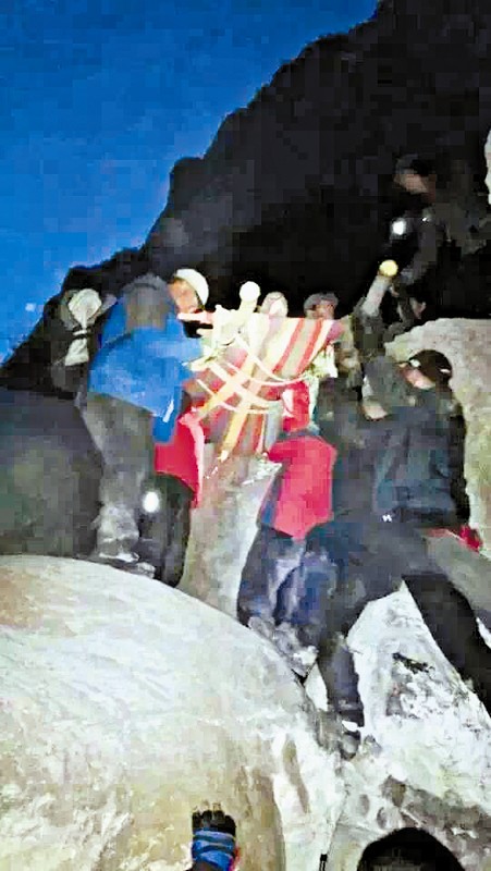 救援隊員用自制的簡易擔(dān)架抬傷者。