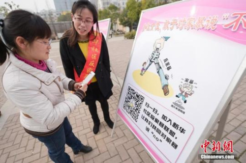 資料圖：今年3月8日，安徽合肥新華社區(qū)志愿者夏一瓊(右)向市民普及反家暴相關(guān)法律知識。鐘欣 攝