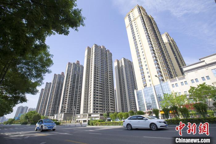 資料圖：車輛從一樓盤前經(jīng)過。 <a target='_blank' href='/'>中新社</a>記者 張?jiān)?攝