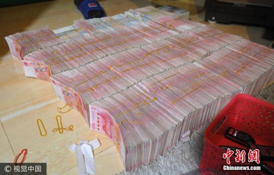 廣西南寧警方8月21日通報，當(dāng)?shù)亟粘晒善粕姘附痤~15.19億元人民幣的特大傳銷案件。圖為當(dāng)場繳獲的成捆現(xiàn)金。圖片來源：視覺中國